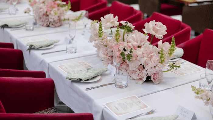 A long table adorned with pink chairs and flowers at The Fullerton Hotel Sydney