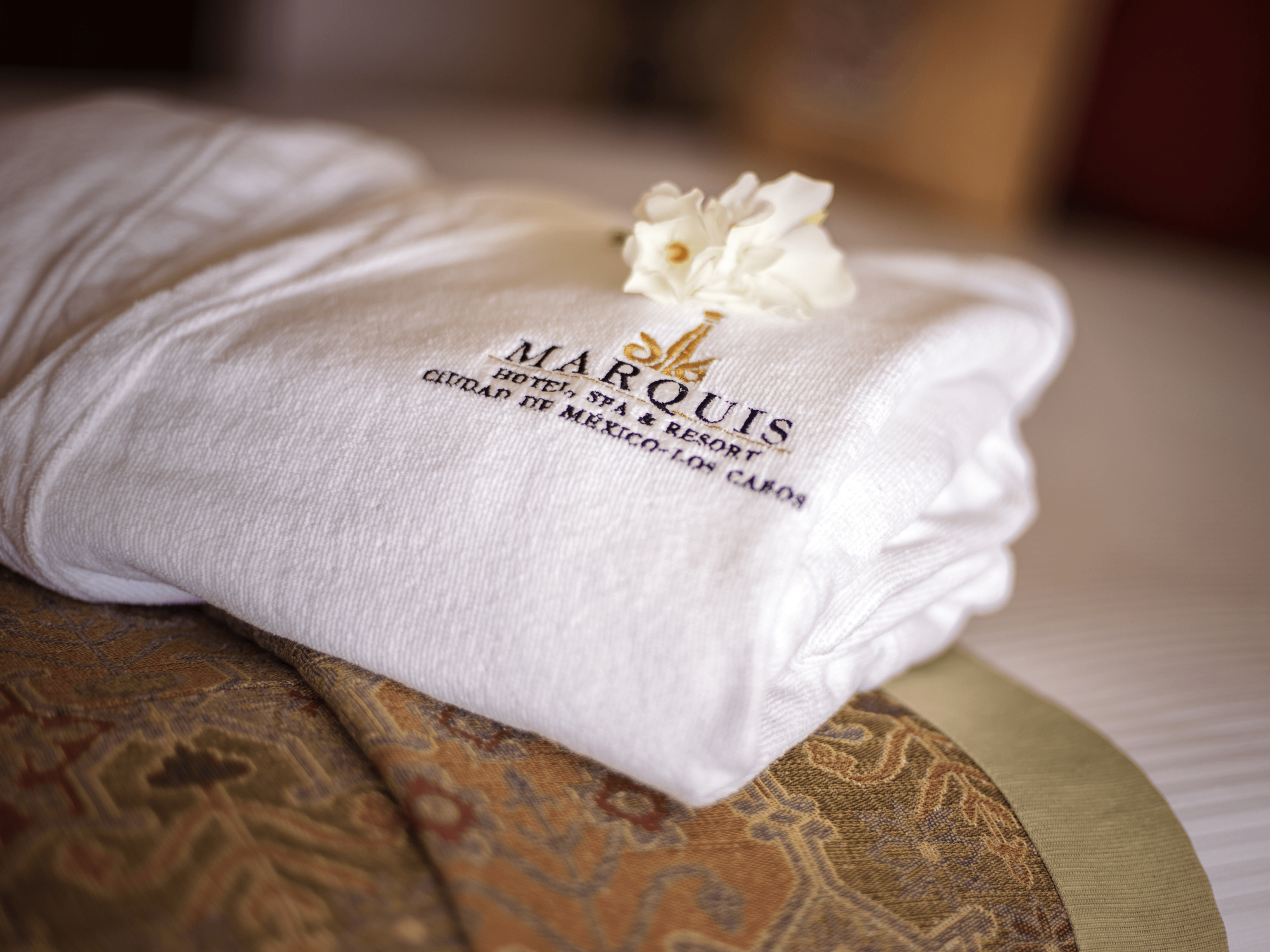Closeup of a folded bathrobe on a bed in Marquis Los Cabos