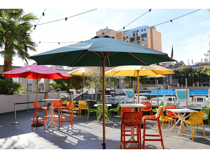 Colorful chairs and umbrellas in outdoor space poolside at Hotel Grand Chancellor Adelaide