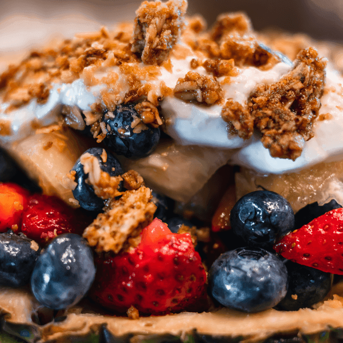 Close up of pineapple filled with mixed berries, topped with yogurt & granola. Breakfast at Avalon Brew Pub