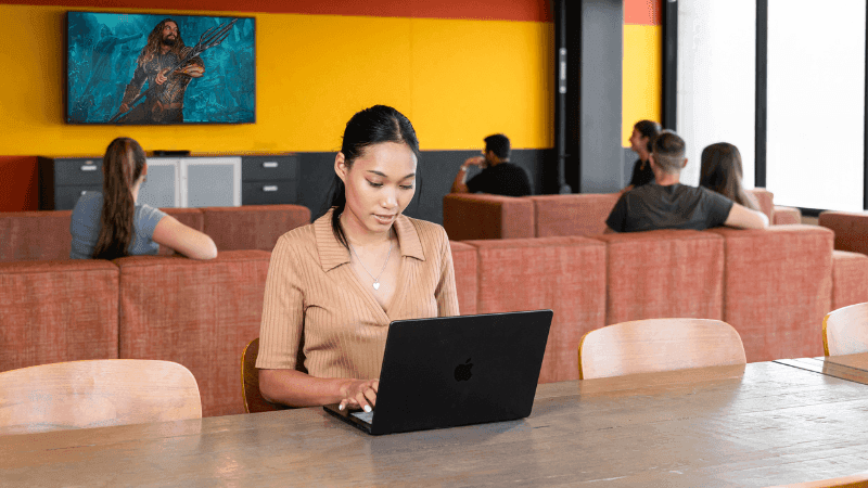Woman working on laptop at a lounge area of StudentLiving Darwin.