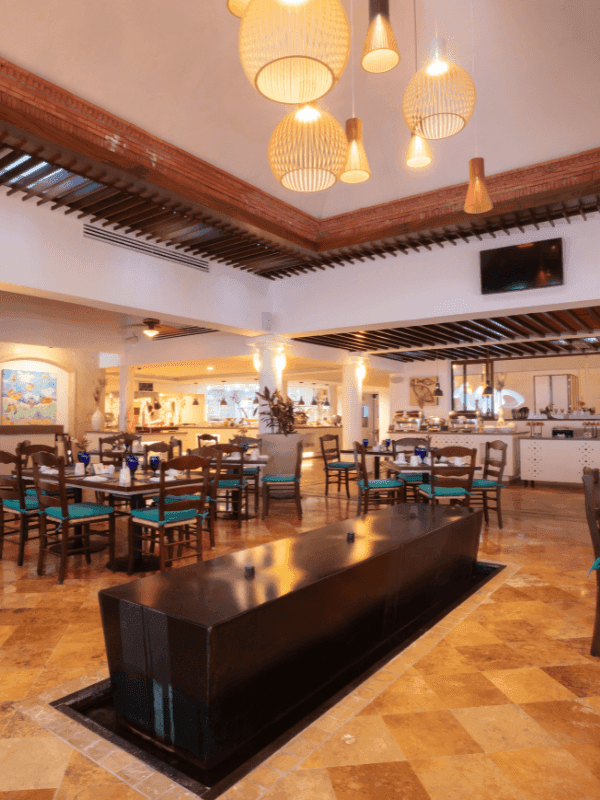 Interior of Frutas y Flores Restaurant with TV and dining tables at Buenaventura Grand Hotel and Spa