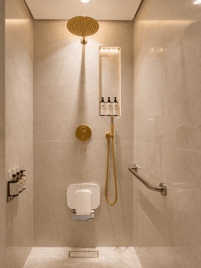 Hand shower fixture and toiletries in Accessible room at Naviti by Warwick Jeddah, showcasing luxurious hotel rooms in Jeddah