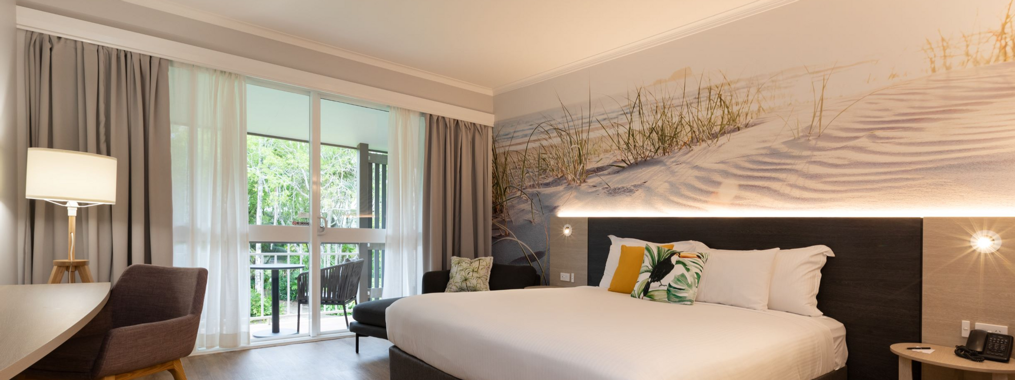 Workdesk facing bed by windows with wooden floors in Executive Rooms at Novotel Sunshine Coast Resort