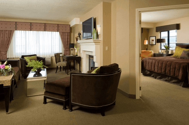 A wide view of a hotel suite with a living area and bedroom.