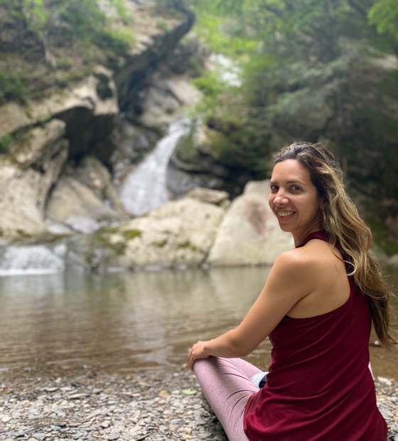 Woman sitting near a waterfall near Honor's Haven Retreat