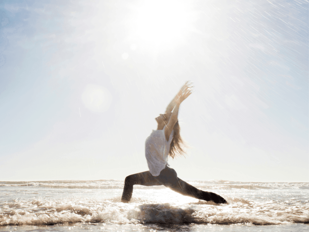 Lady doing yoga in the beach on a sunny day near Golf Hotel Punta Ala