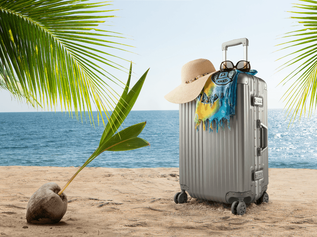 Suitcase bag with hat & sunglasses near a beach at Amora Hotel