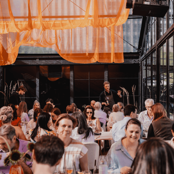 Guests dining and listening to a chef at Tasting Australia event.