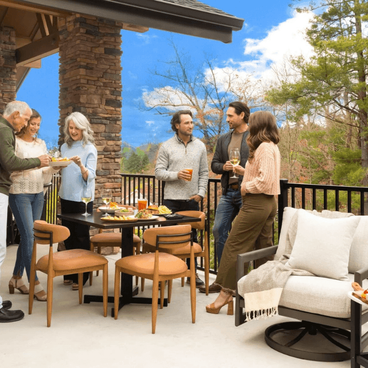 A group of guests mingling on the outdoor patio with wine and charcuterie boards