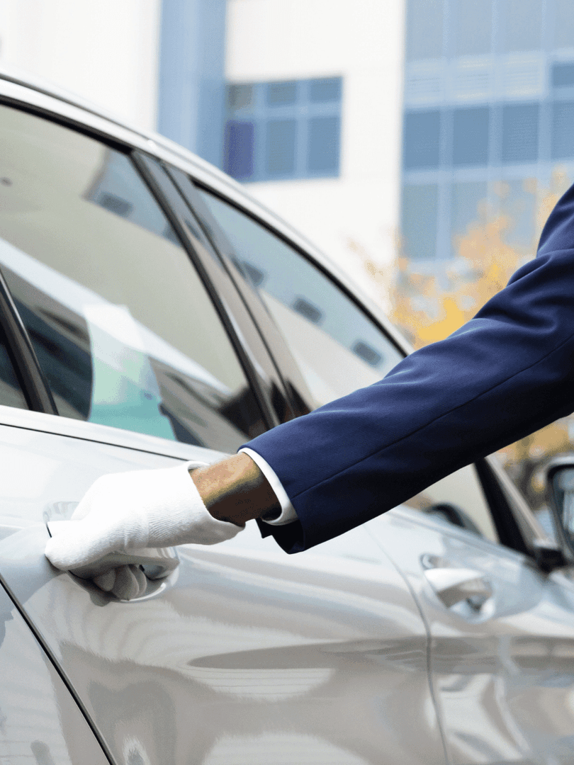 Gros plan sur un chauffeur de taxi ouvrant la porte pour le service de voiturier au Warwick Le Crystal.