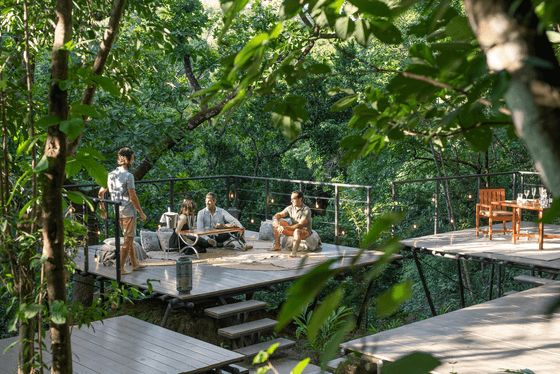 Friends lounging on the terrace overlooking the forest at Hotel Rio Perdido