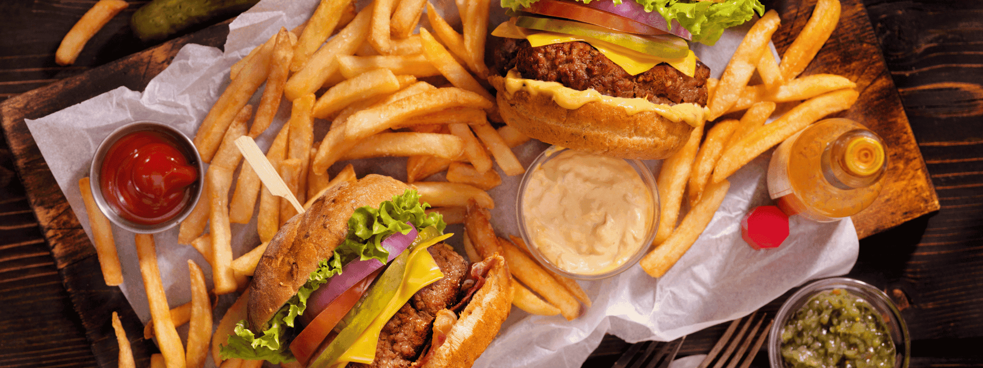 Two cheesy burgers with fresh toppings and golden fries served at Novotel Sydney International Airport