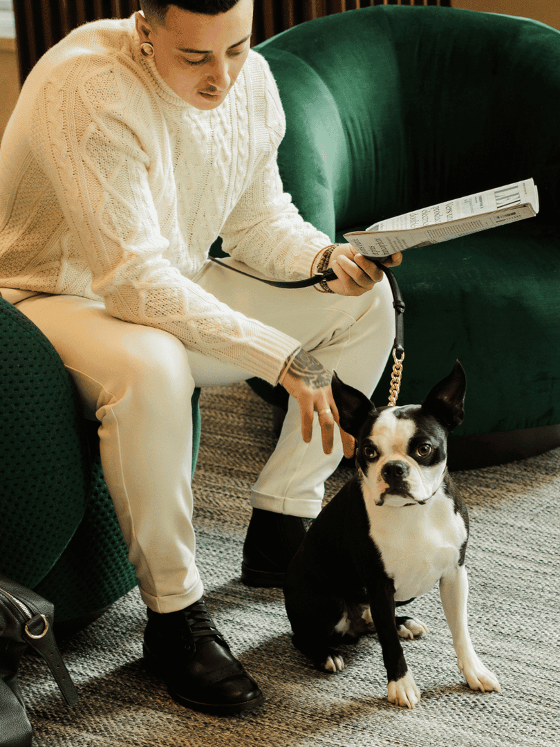 Un homme avec son chien sur le confortable canapé du hall du Warwick Le Crystal.