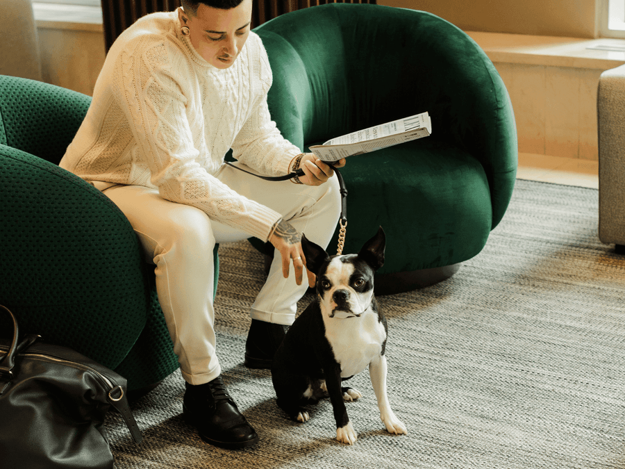 Un homme avec son chien sur le confortable canapé du hall du Warwick Le Crystal.