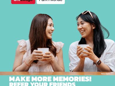 Two female students holding coffee cups against a turquoise background with UniLodge Park Avenue branding and referral promotion.
