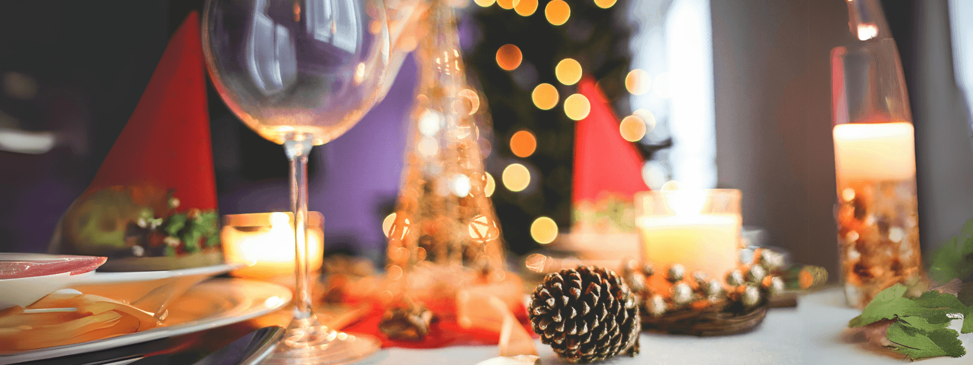 Blurred festive table with wine glass, pinecone, and warm lights at Novotel Sydney International Airport