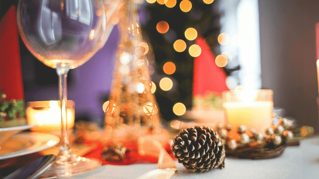 Blurred festive table with wine glass, pinecone, and warm lights at Novotel Sydney International Airport
