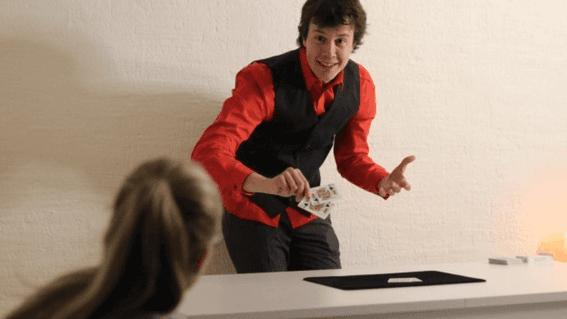 Magician performing card trick at a table, one of the Lausanne activities in Hotel Starling Lausanne