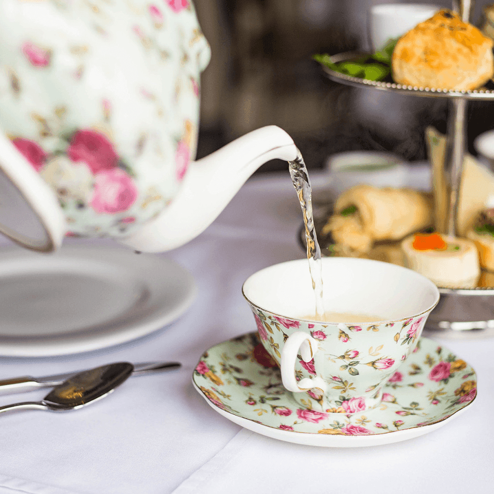 A teapot pouring hot water into a teacup in Pendray Tea House at Pendray Inn & Tea House