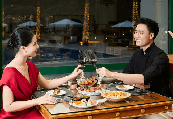 Couple toasting wine glasses in restaurant at Hanoi Daewoo