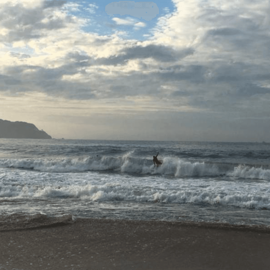 A man surfing against the tide waves near Cala de Mar Resort