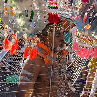 A kavadi bearer with body and facial piercings during thaipusam in penang.