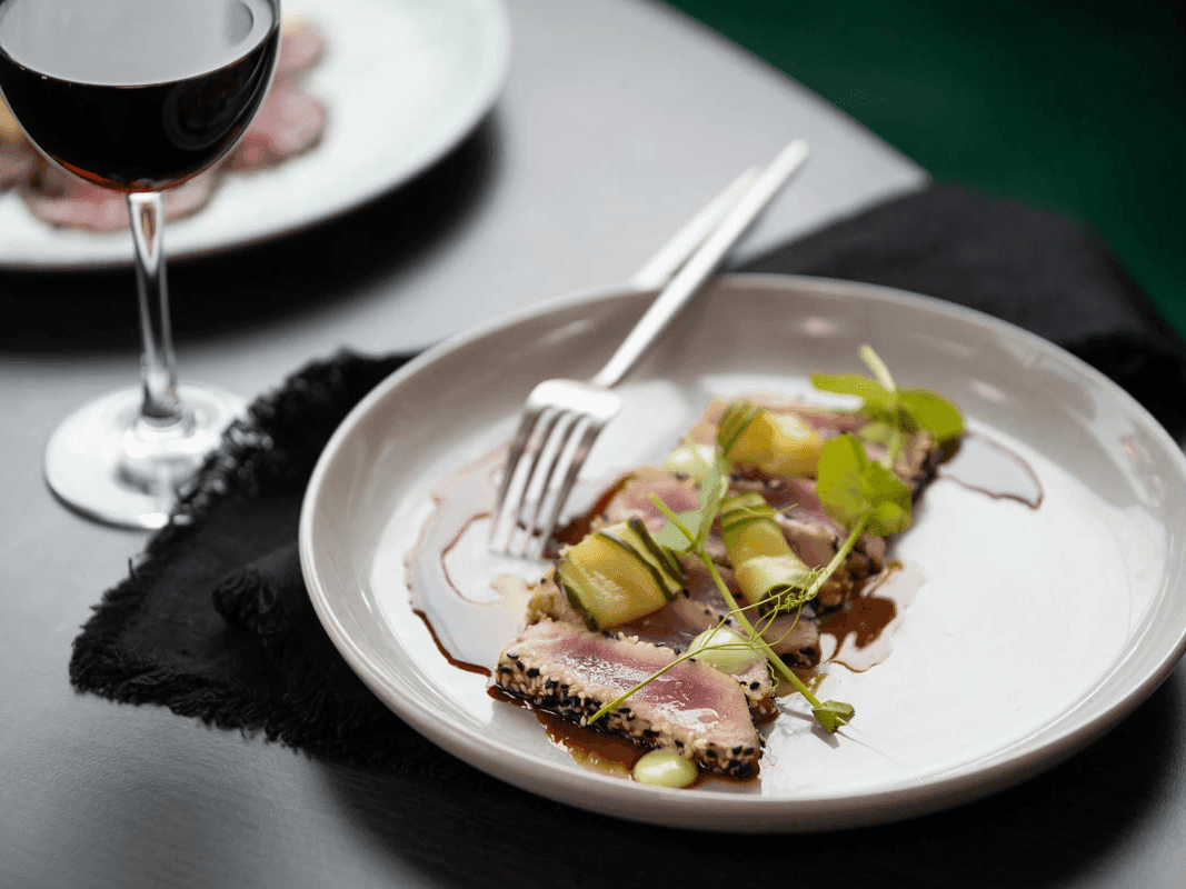 Plate with tuna and vegetable dish served on a white plate at Pullman Magenta Shores