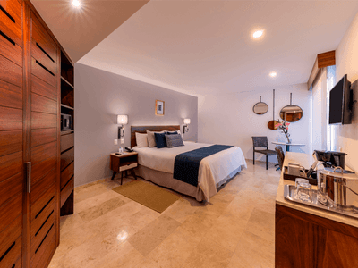 Deluxe King Bed with bed, side tables, lamps and a coffee station at Buenaventura Grand Hotel and Spa