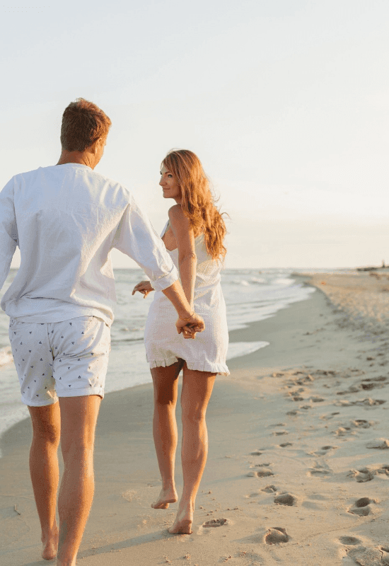 Couple walking on the beach near Marea Beachfront Villas