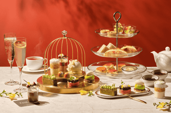 A vibrant afternoon tea set with sweet and savory treats served on tiered stands at Carlton Hotel Singapore
