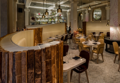 Modern restaurant interior with wooden accents, round tables, and stylish lighting at The Kitchens
