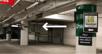 Underground parking facility with concrete pillars and entrance sign with arrow pointing left near Hotel X Toronto site