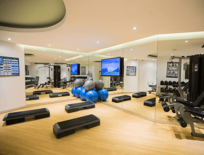 Fully Equipped Gym interior with stability balls, step platforms, and TV at Buenaventura Grand Hotel and Spa