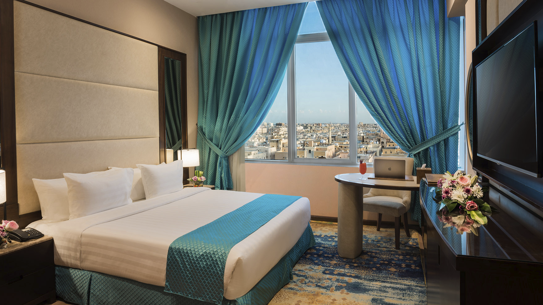 Junior Suite interior with a city view at Naviti By Warwick Dammam