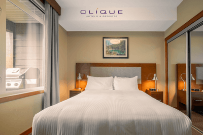 Cozy bedroom at Falcon Crest Lodge features a comfortable king-size bed, bedside tables with lamps, and a window