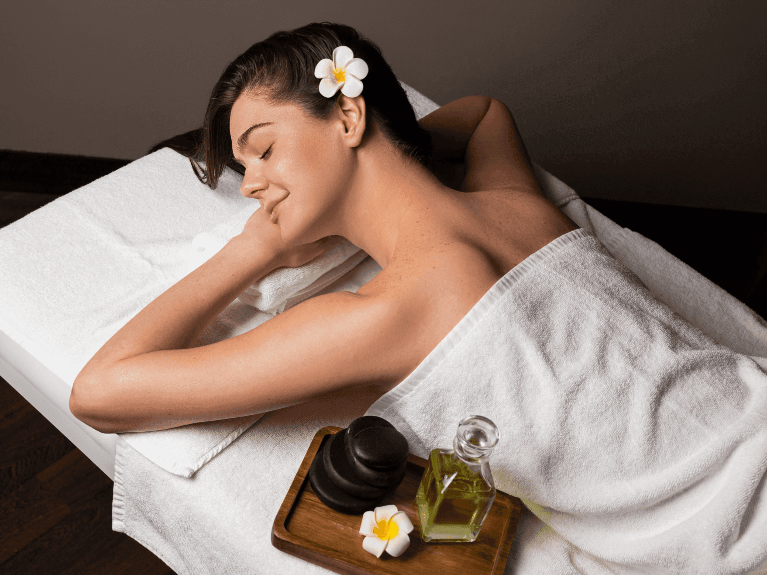 Woman enjoying calming spa treatment with flower detail and oils for wellness in Dreamworks Spa at DAMAC Maison Distinction