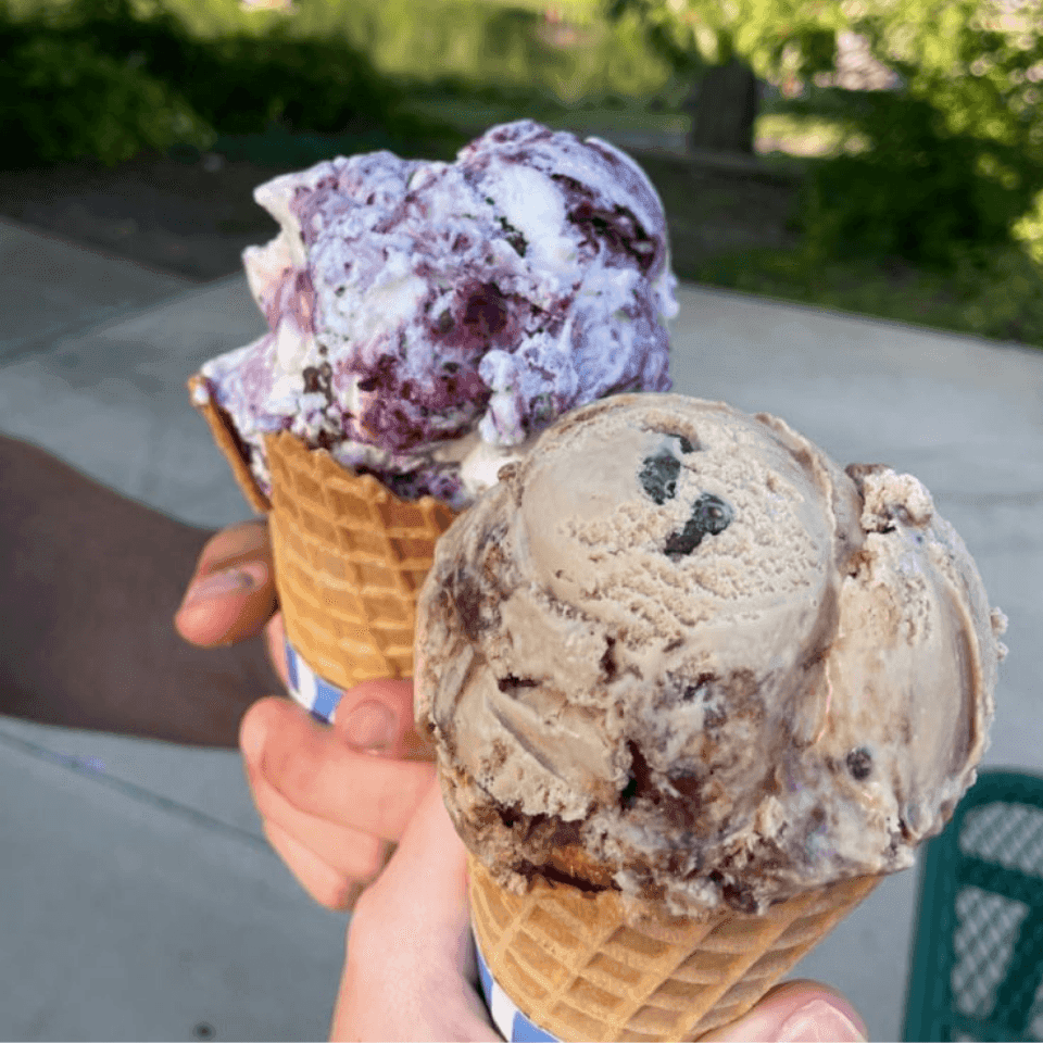 two hands holding ice cream cones