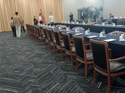 APEC 2024 conference setup with a long table, surrounded by attendees at Hotel Los Delfines & Casino