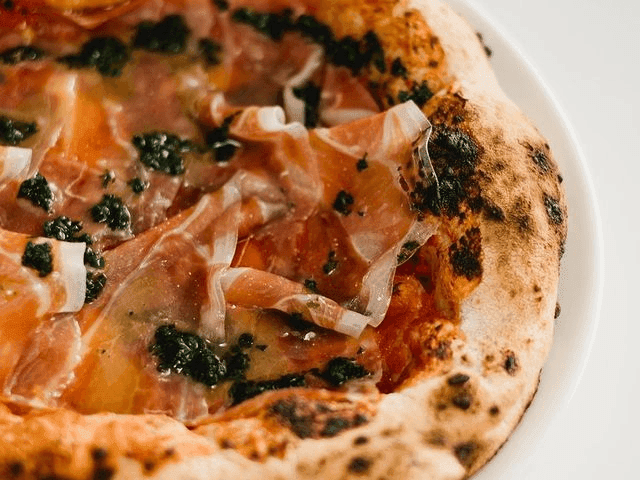 Close-up of a pizza served in Romo Pizza Bar at Brady Apartment Hotel Flinders Street