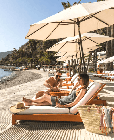 Couple relaxing on a sunbed while having drinks by the Beach near Catalina Island Company