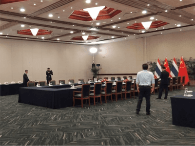 APEC 2024 conference setup featuring a long table with flags of China and Thailand at Hotel Los Delfines & Casino