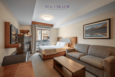 Comfortable suite at Falcon Crest Lodge features a king-size bed, a cozy sofa, a fireplace with decorative moose