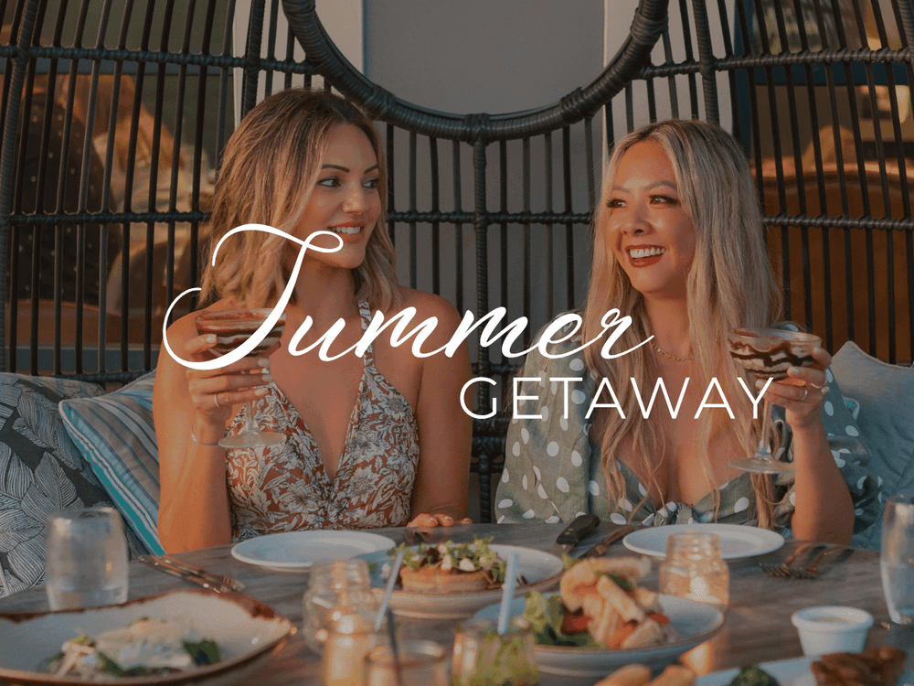 Two women enjoying a meal with wine glasses on a table with Summer Getaway text.
