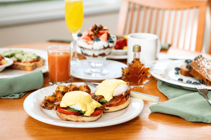 Breakfast spread with eggs, potatoes, fruit, and beverages at Anchorage By The Sea