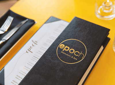 Open menu for Epoch Restaurant & Bar, with a black and gold cover, an upscale dining option at The Exeter Inn
