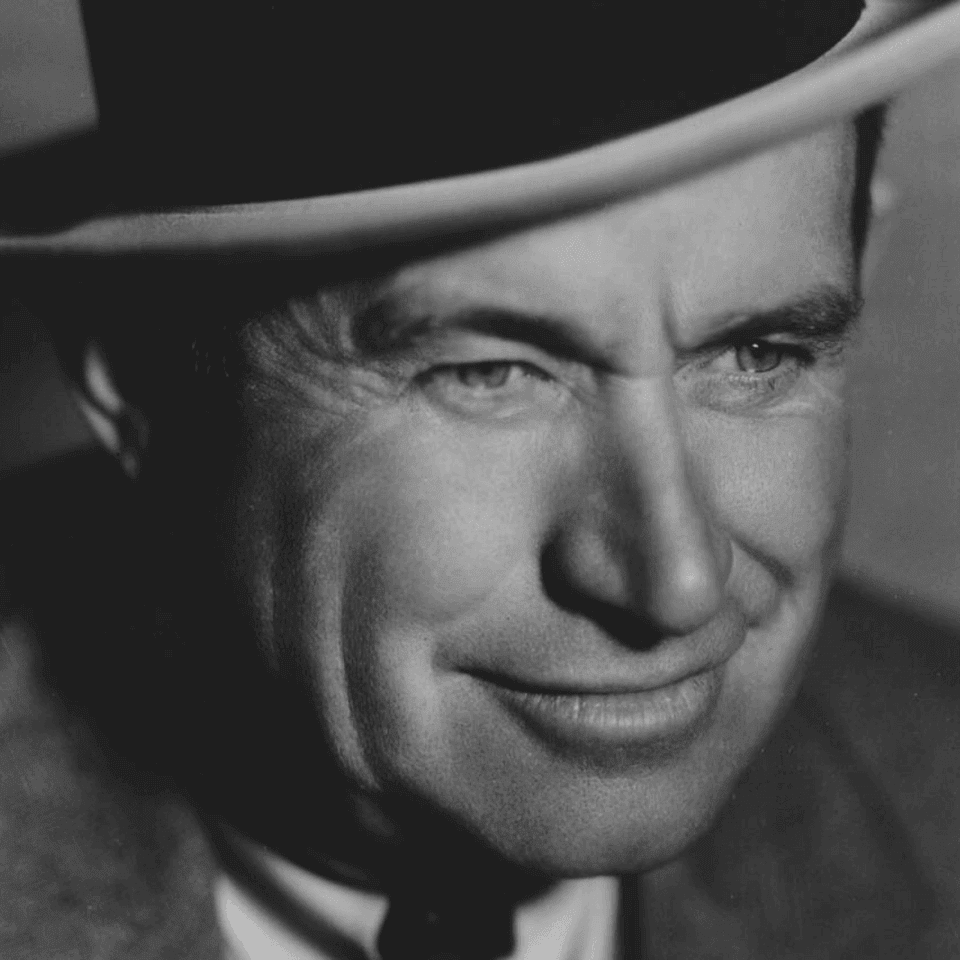 Black and white close-up portrait of Will Rogers smiling under a wide-brimmed hat near Arlington Resort Hotel & Spa