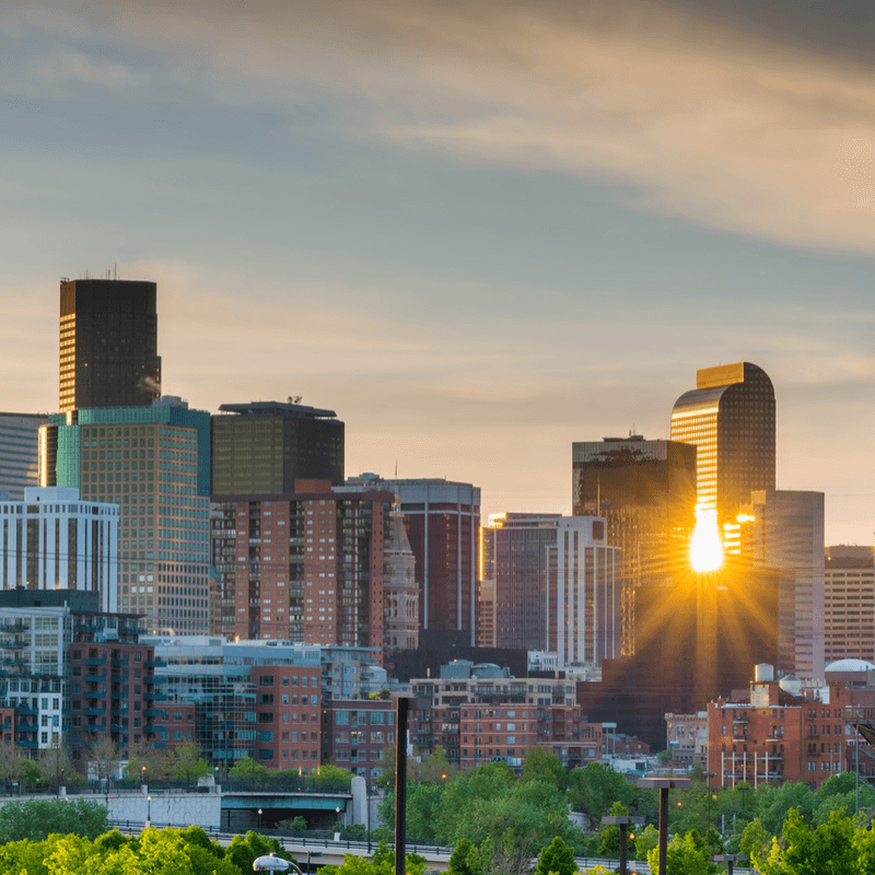 Denver skyline with the sun reflecting off buildings near Warwick Denver
