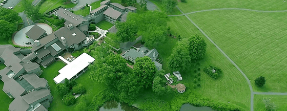 Aerial view of conference center with event tent surrounded by lush green lawns at Aramark Chauncey Conference Center