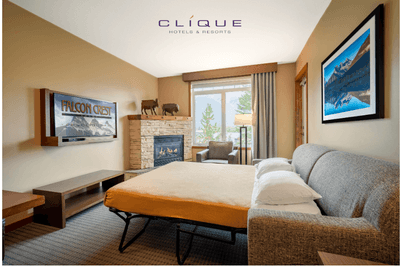 Suite at Falcon Crest Lodge features a comfortable sofa bed, a fireplace and a scenic window view